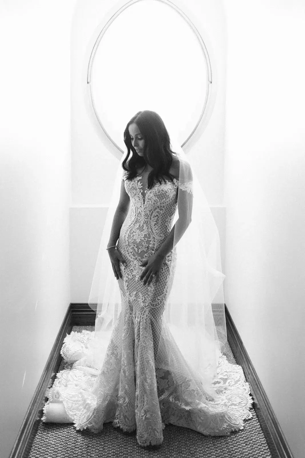 Bride standing by a window in her wedding dress