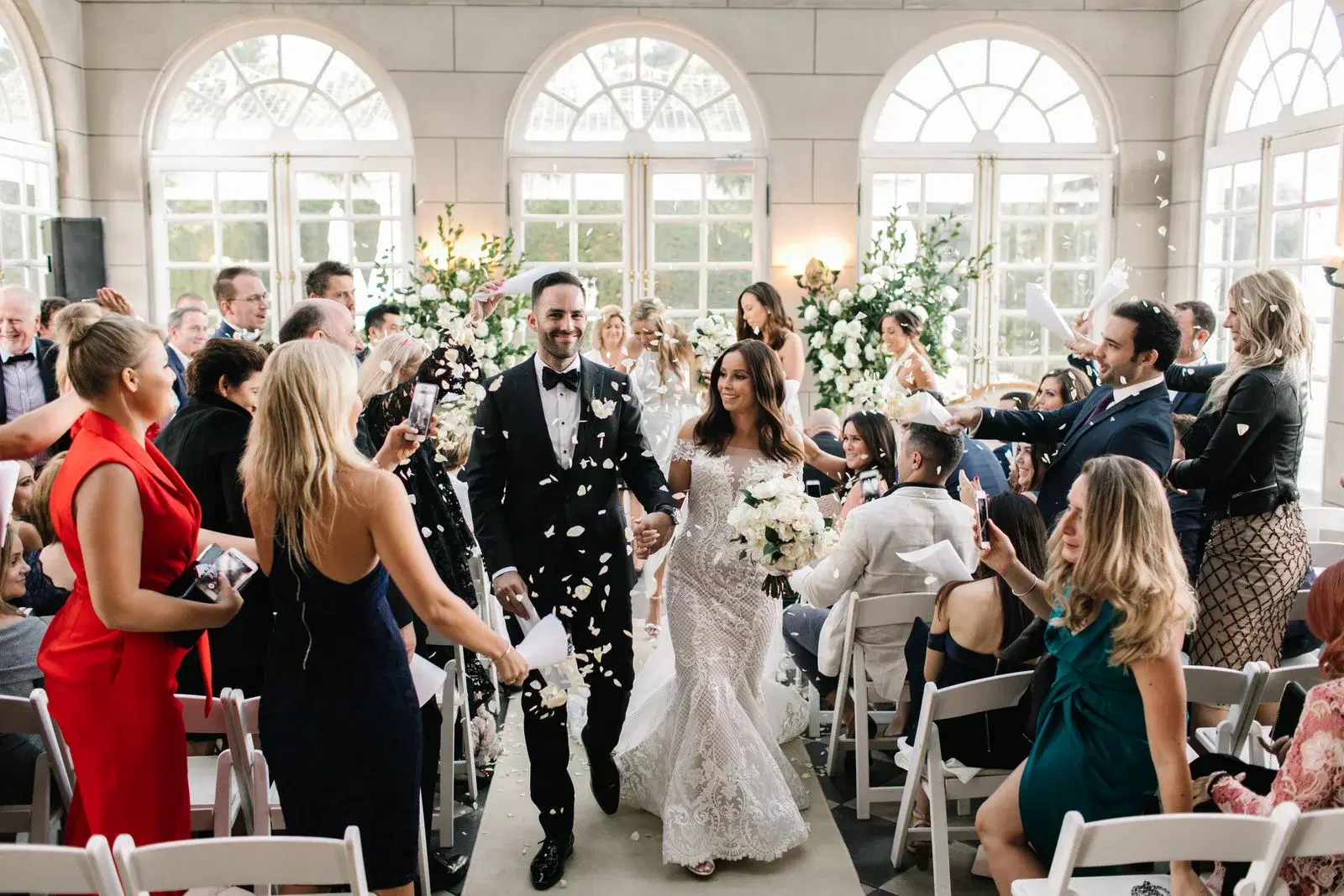 Newlyweds walking through their guests after the ceremony